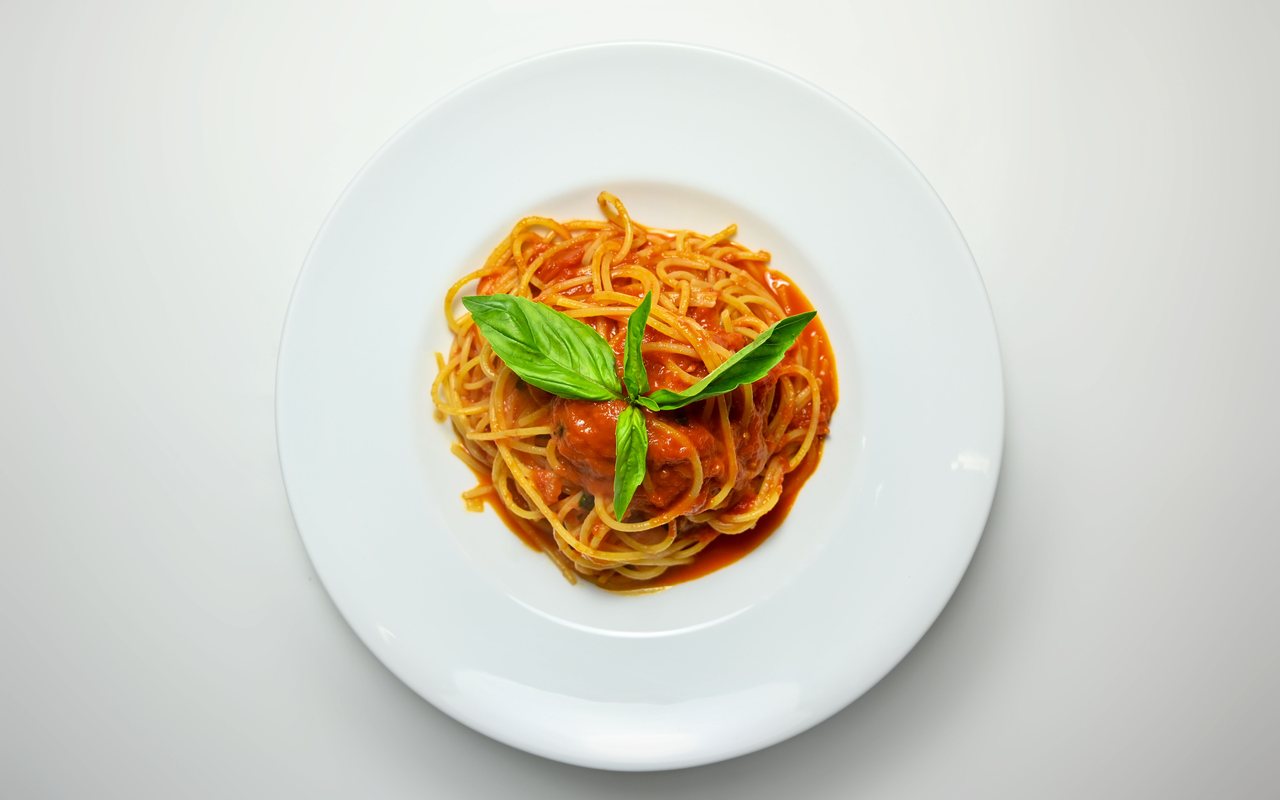Spaghetti coated in bright tomato sauce and topped with grated cheese