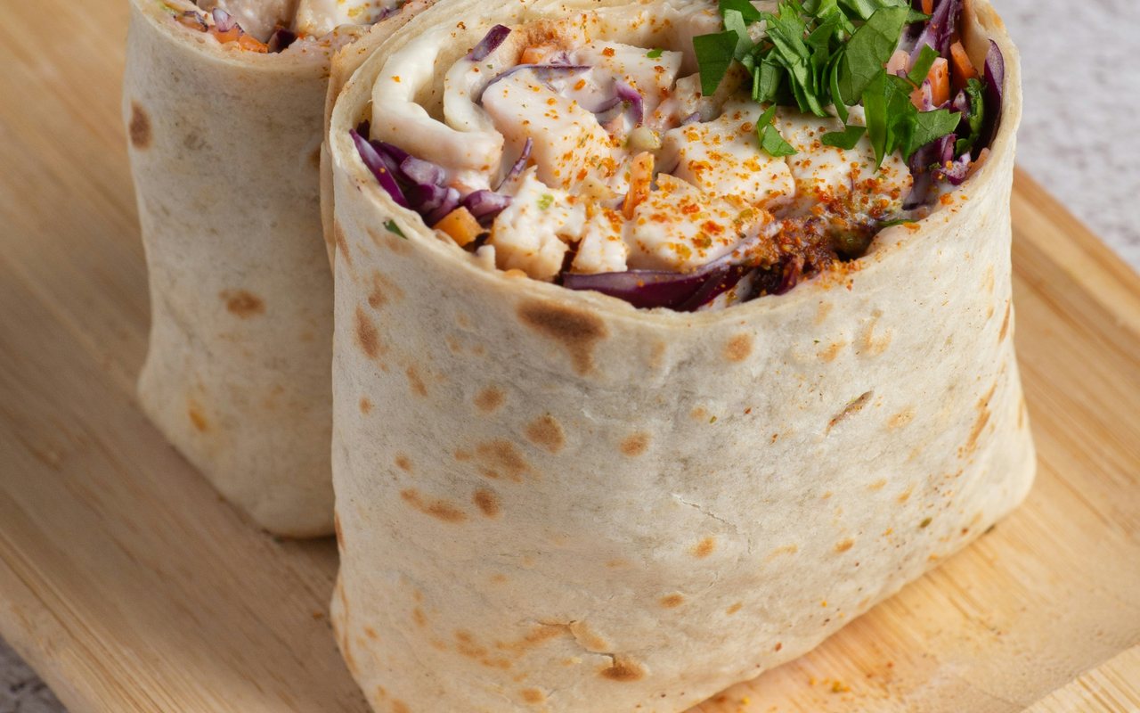 Chicken tortilla wraps filled with cabbage, carrots, herbs, and creamy sauce.