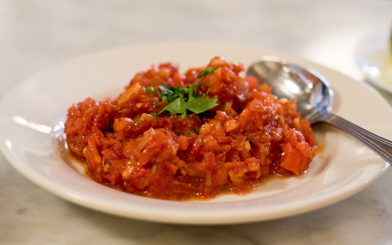 Finely chopped red acılı ezme with tomato, pepper, onion, and parsley on a white plate