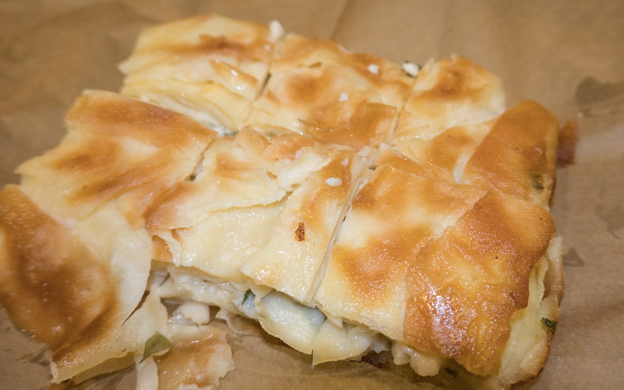 Round layered peynirli börek with a golden sesame crust