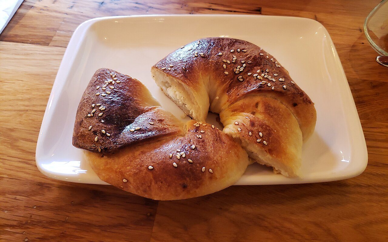 Glossy twisted Turkish açma rolls on a baking tray