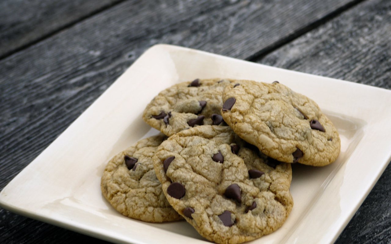 Chocolate chip cookies with lightly golden edges on a cooling rack