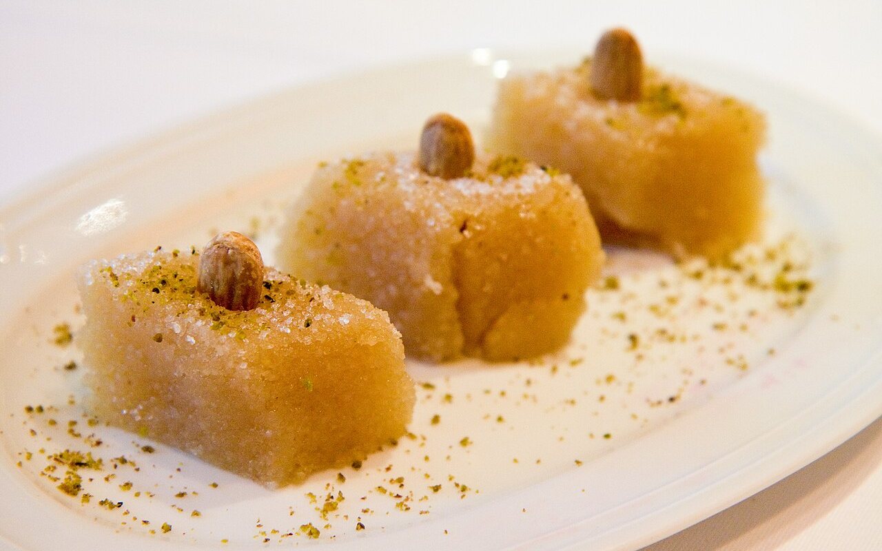 Molded Turkish semolina halva topped with cinnamon and pine nuts