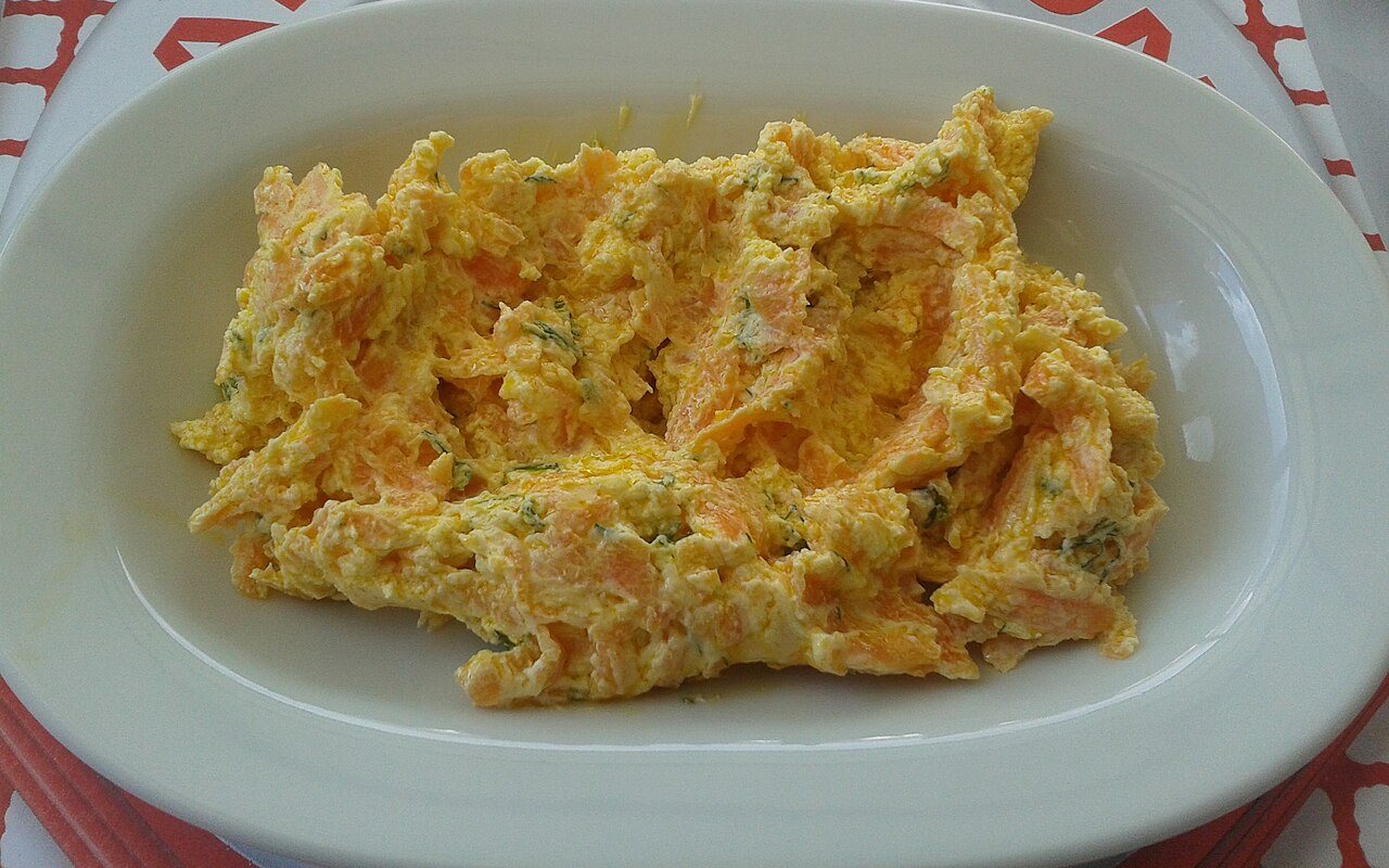 Creamy carrot-yogurt salad topped with walnut pieces