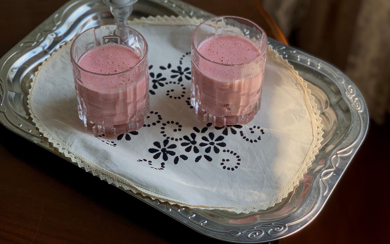 Two glasses of pale pink fruit protein milkshake
