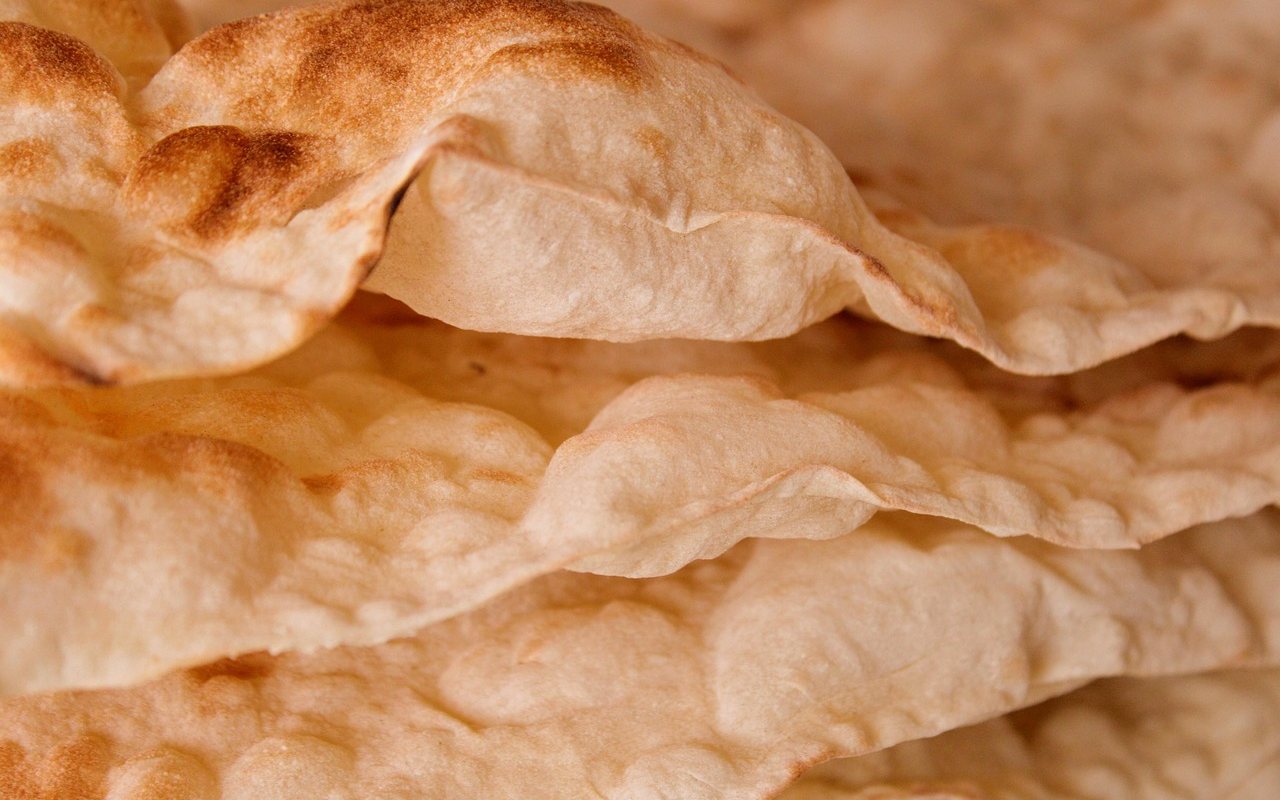Close-up of thin, blistered lavash flatbreads layered in a stack