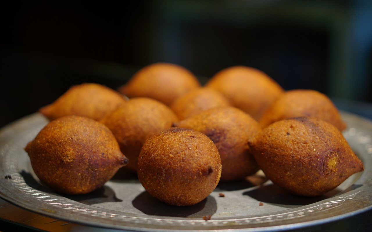 Golden oval içli köfte with pointed ends, one cut open to show the beef and walnut filling