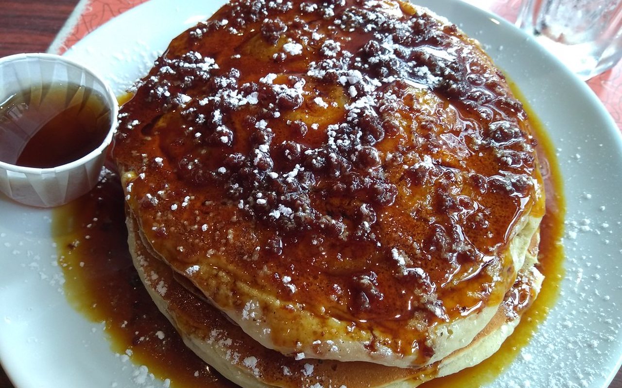 Six small banana-oat protein pancakes stacked on a plate