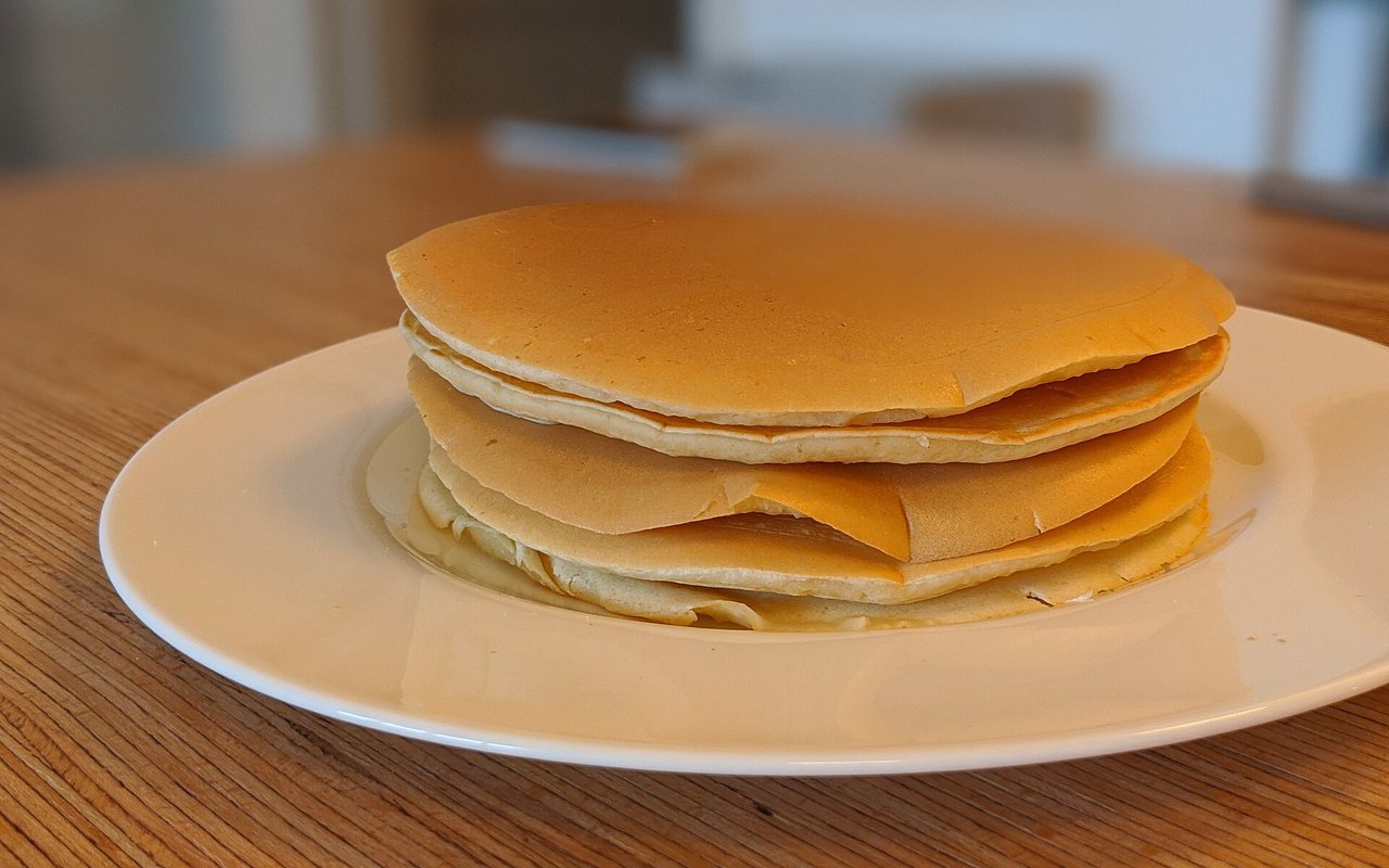 Stack of small golden pancakes served for breakfast