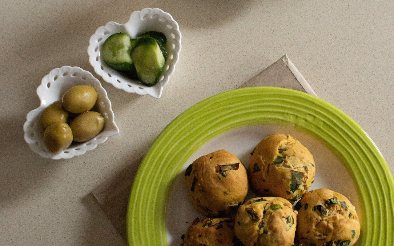 Golden oval dill poğaça filled with white cheese on a baking tray