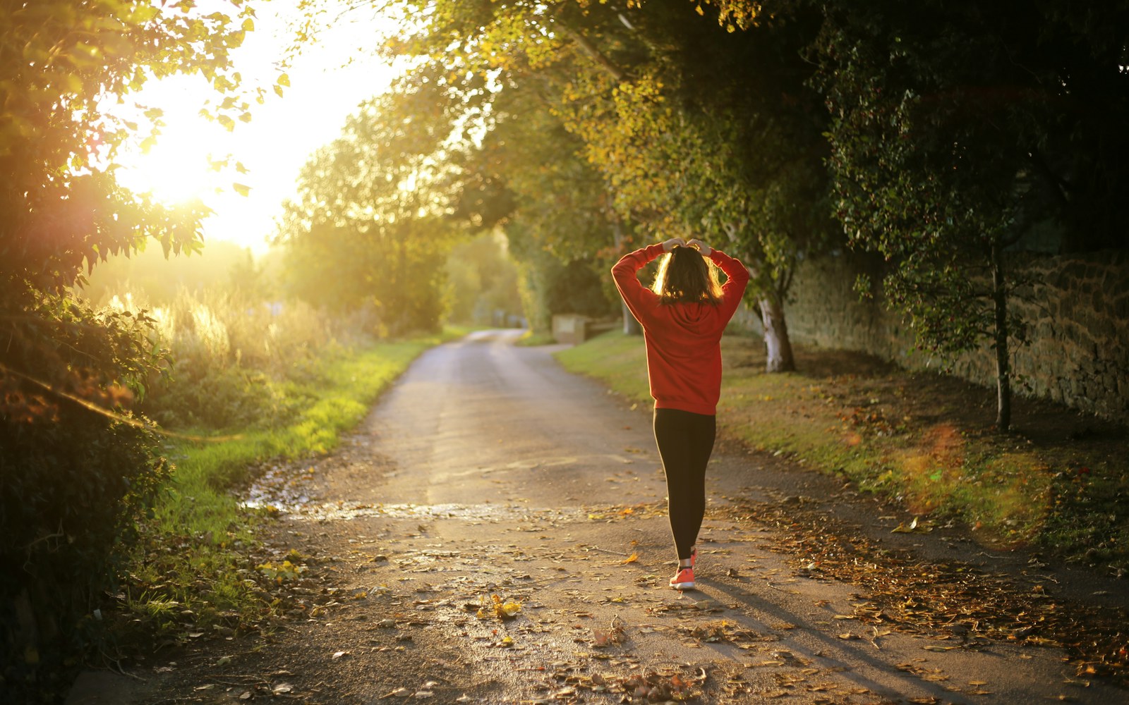 Woman takes an easy walk along a sunlit country lane