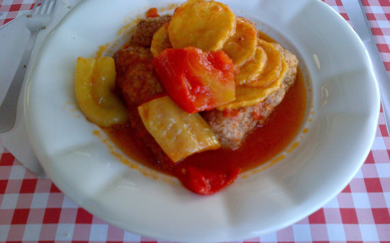 İzmir köfte meatballs baked with potato wedges, green peppers, and tomato sauce