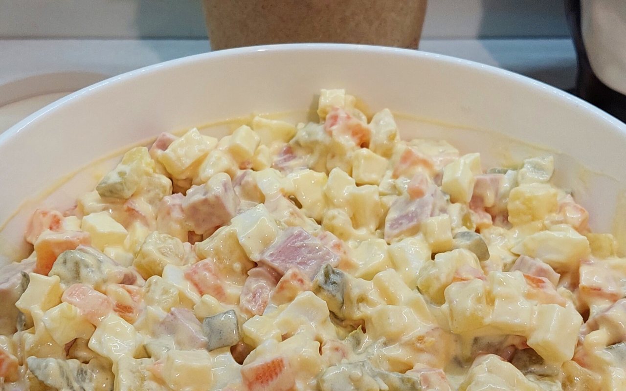 Creamy potato, carrot, pea, and cornichon salad garnished with dill