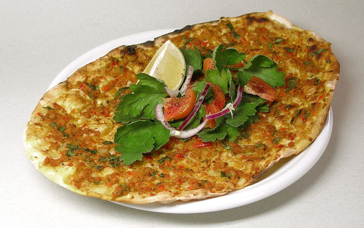 Thin lahmacun flatbreads topped with spiced ground meat and vegetables
