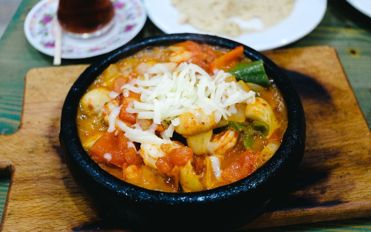 Shrimp in tomato sauce under browned melted cheese in a small casserole dish