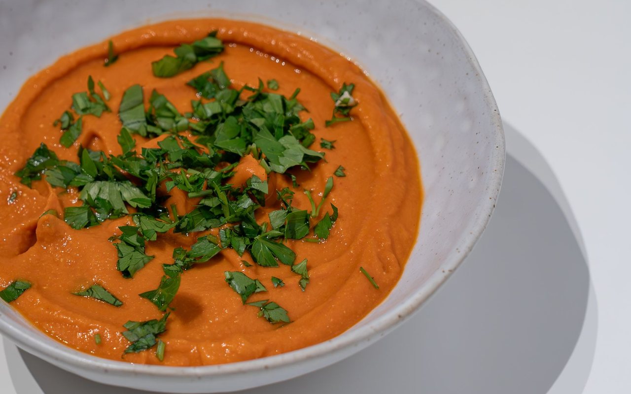 Orange carrot soup topped with finely chopped dill