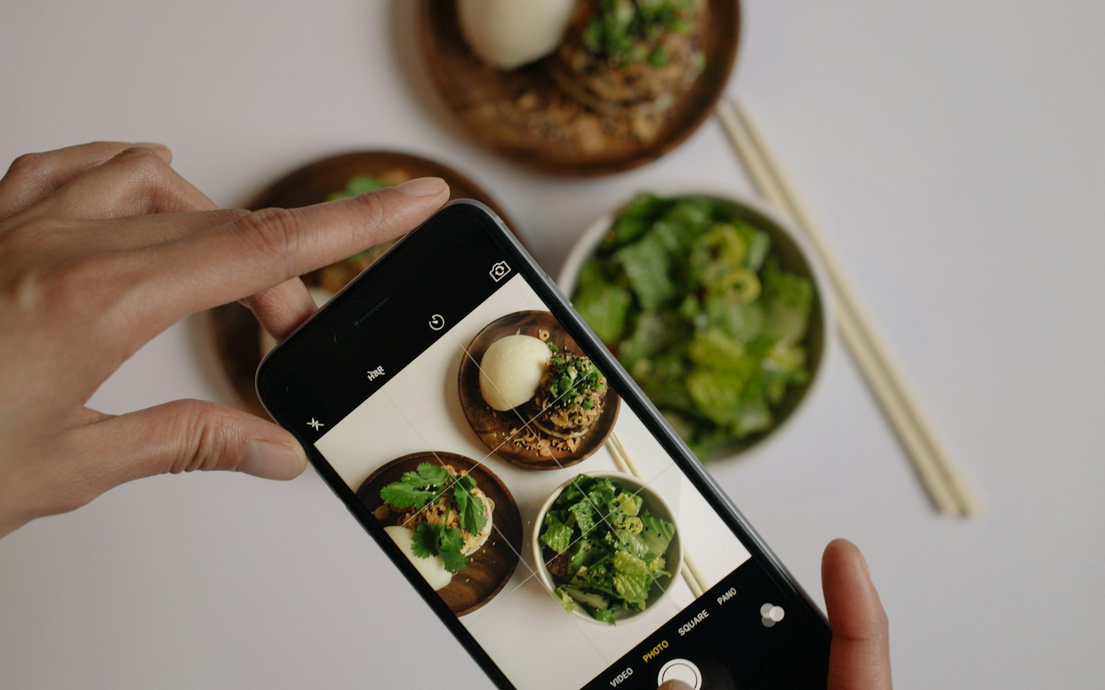 Person uses a smartphone camera to photograph a meal