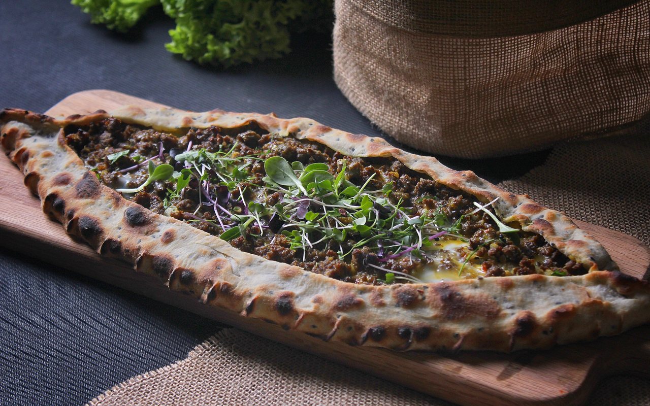 Boat-shaped Turkish pide filled with ground beef, tomato, onion, and green peppers