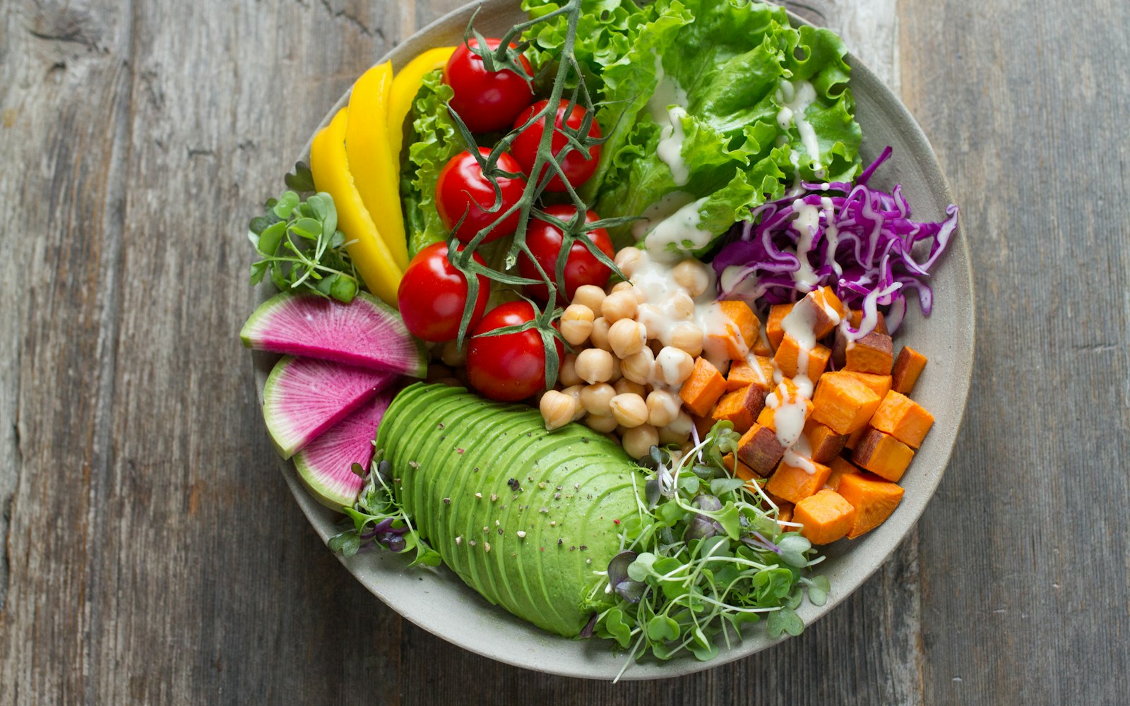 Colourful bowl with chickpeas, sweet potato, avocado, and vegetables