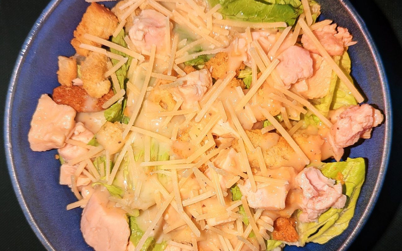 Chicken Caesar-style salad with romaine, croutons, and grated cheese