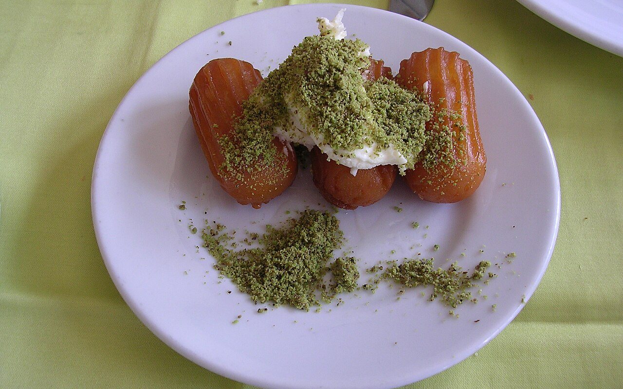 Golden ridged tulumba pastries glistening with syrup on a serving plate