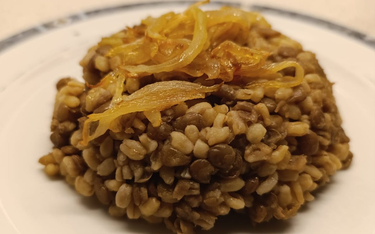 Molded bulgur and green lentil pilaf topped with caramelized onions