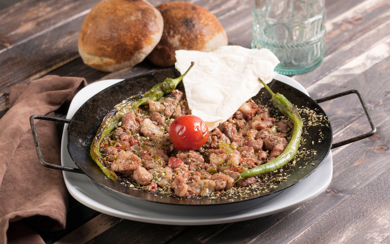 Diced beef sautéed with green peppers, onion, and tomato sauce in a skillet