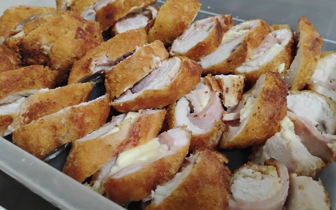 Sliced breaded chicken cordon bleu filled with melted cheese and beef ham