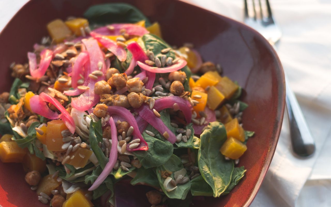 Chickpea salad with chopped pickles, lettuce, tomatoes, onion, and small peppers