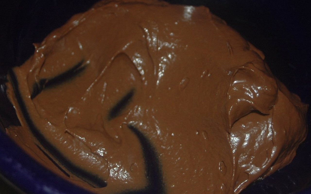 Six bowls of glossy dark chocolate pudding