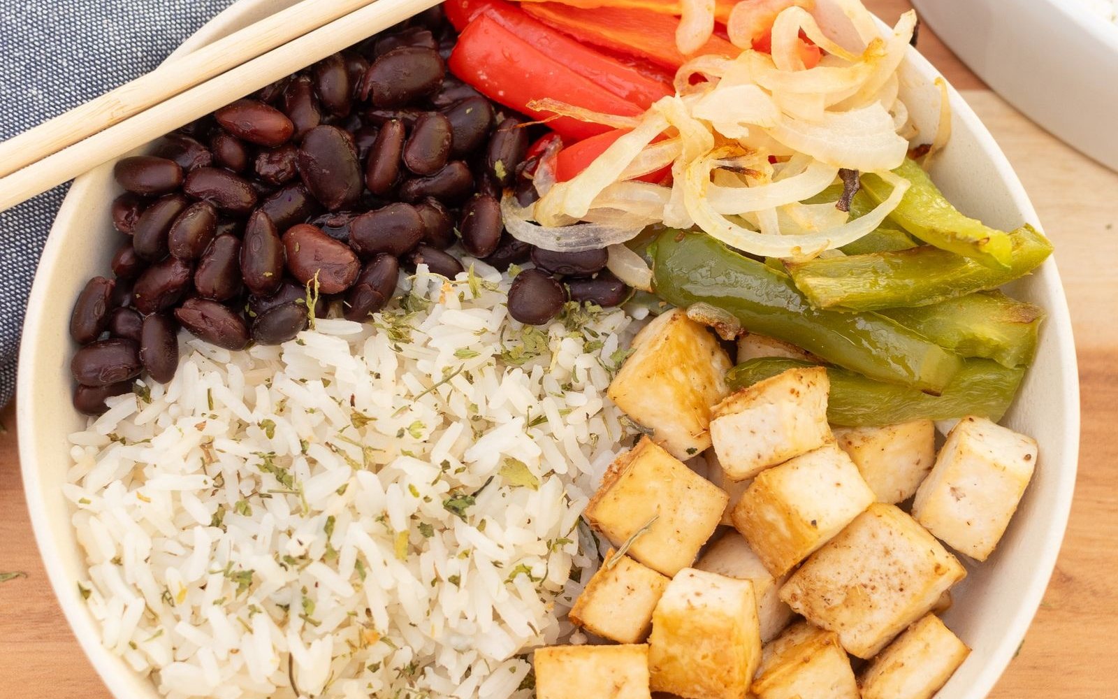 Bowl of black beans, rice, tofu, peppers, and onions.