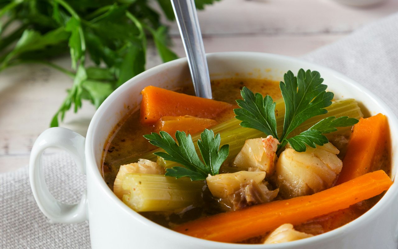 White fish and vegetable soup with carrots, celery, and parsley