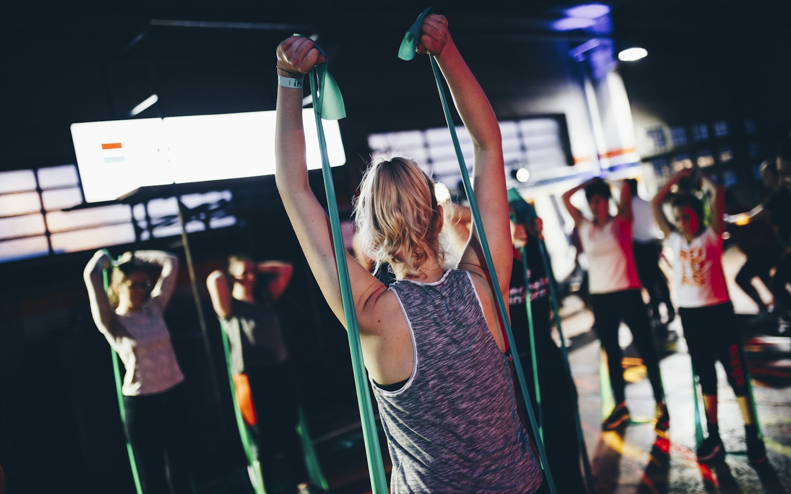 Person raises resistance bands during a group exercise class