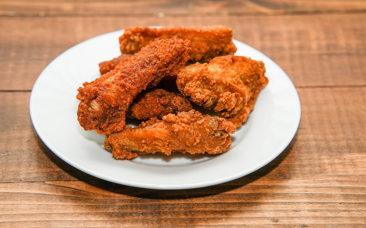Crispy golden fried chicken wings piled on a serving plate