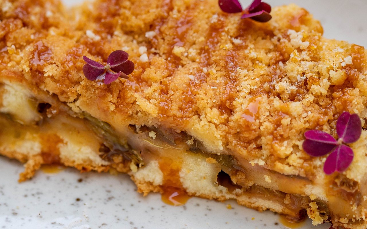 Close-up of baked apple crumble with a golden crumb topping and visible apple layer