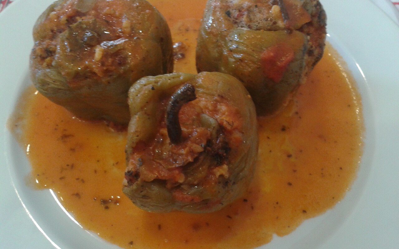 Colorful bell peppers filled with beef and rice in tomato sauce