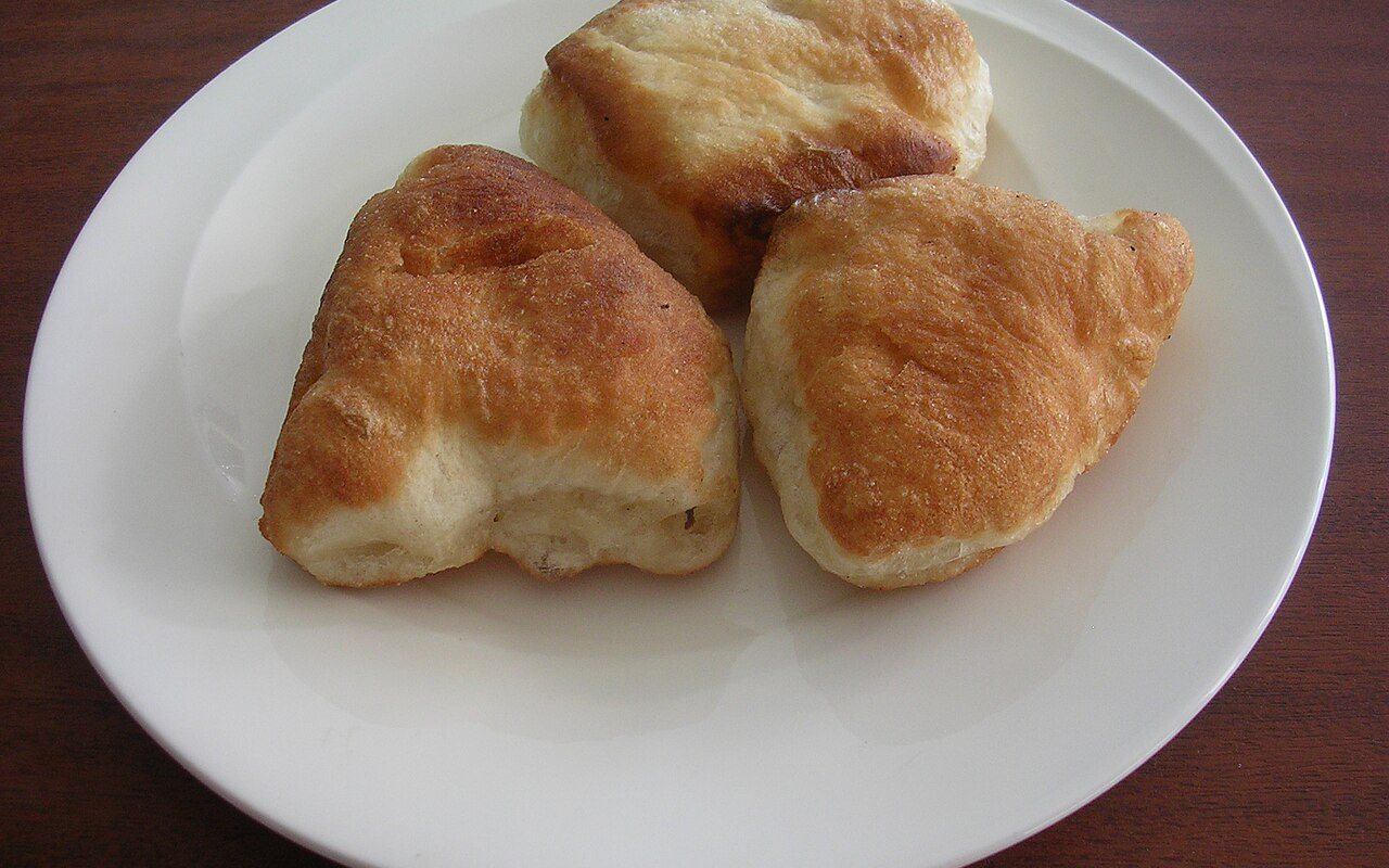 Golden ring-shaped Turkish pişi draining after frying