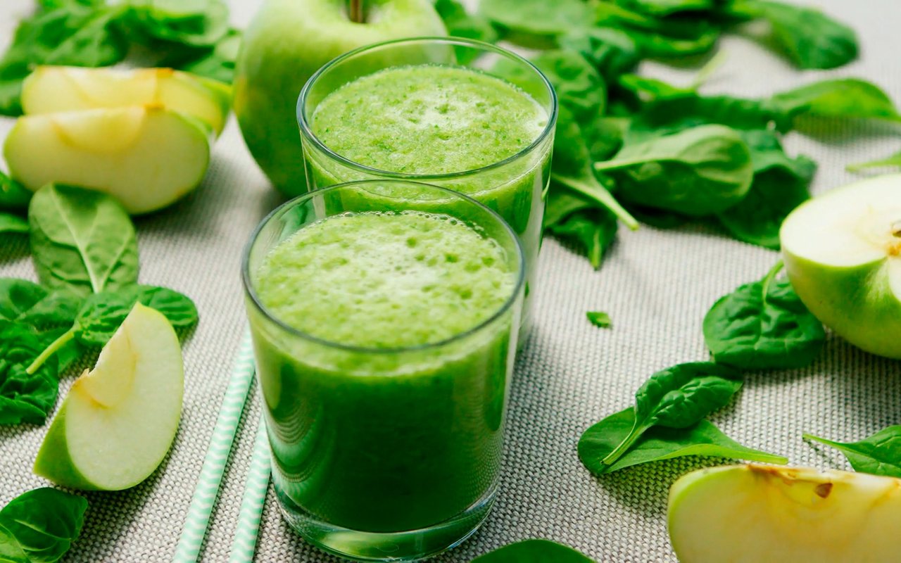 Two glasses of bright green avocado and spinach smoothie