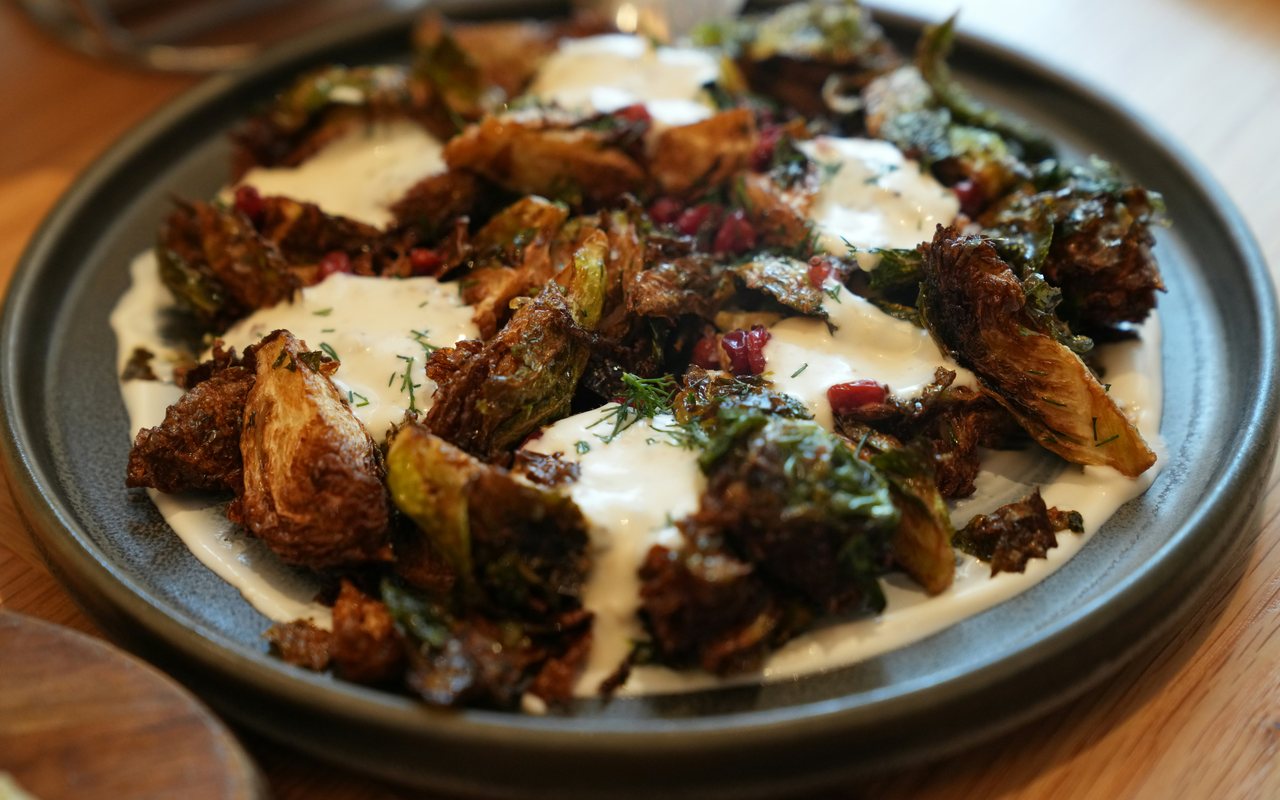 Roasted Brussels sprouts with creamy herb sauce and pomegranate seeds.