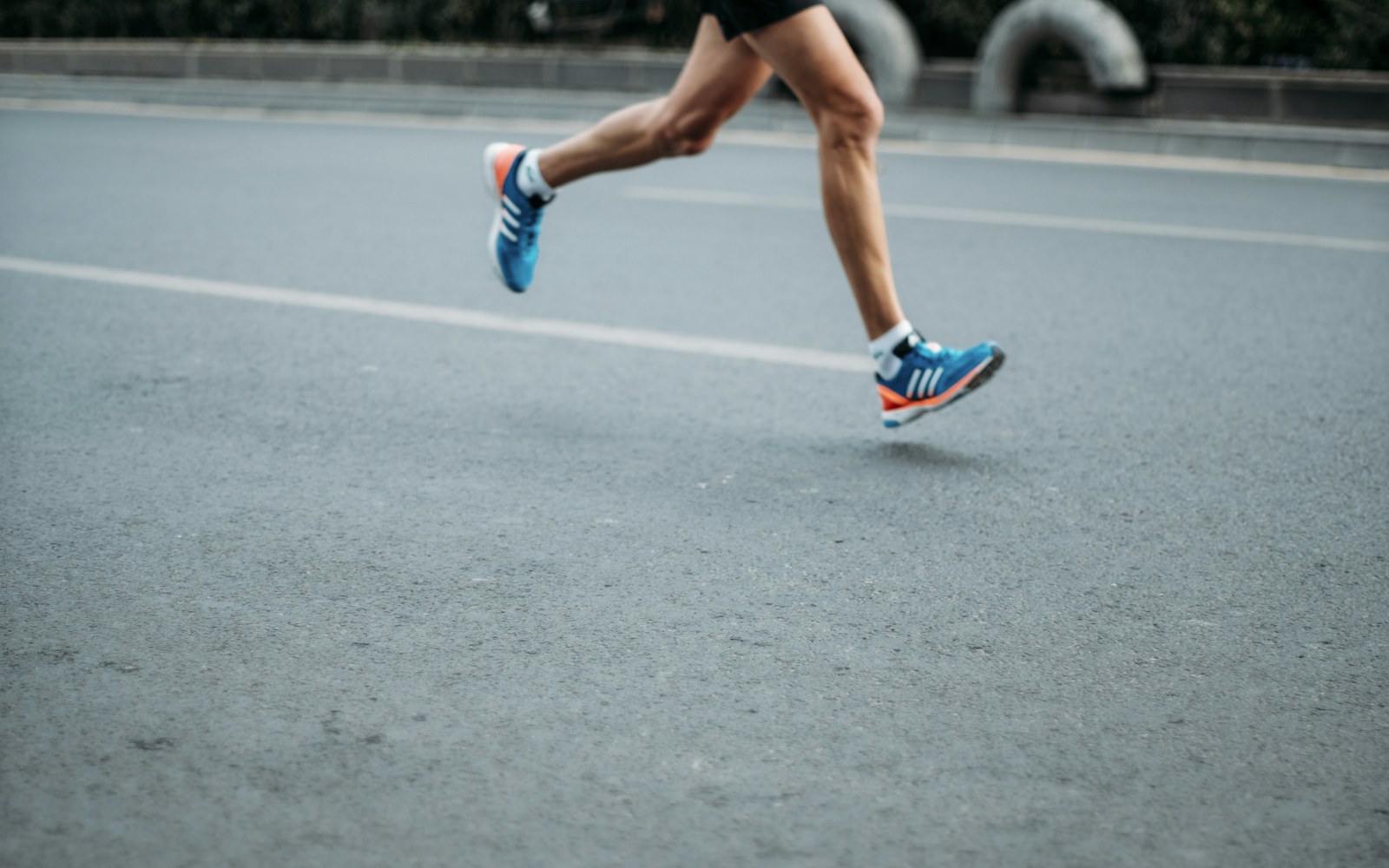 Runner's legs in motion on a city road