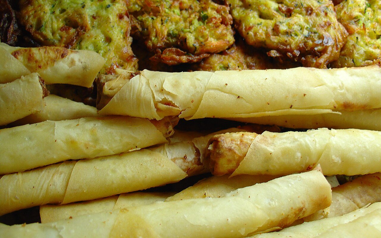 Crisp golden Turkish cheese rolls stacked on a serving plate