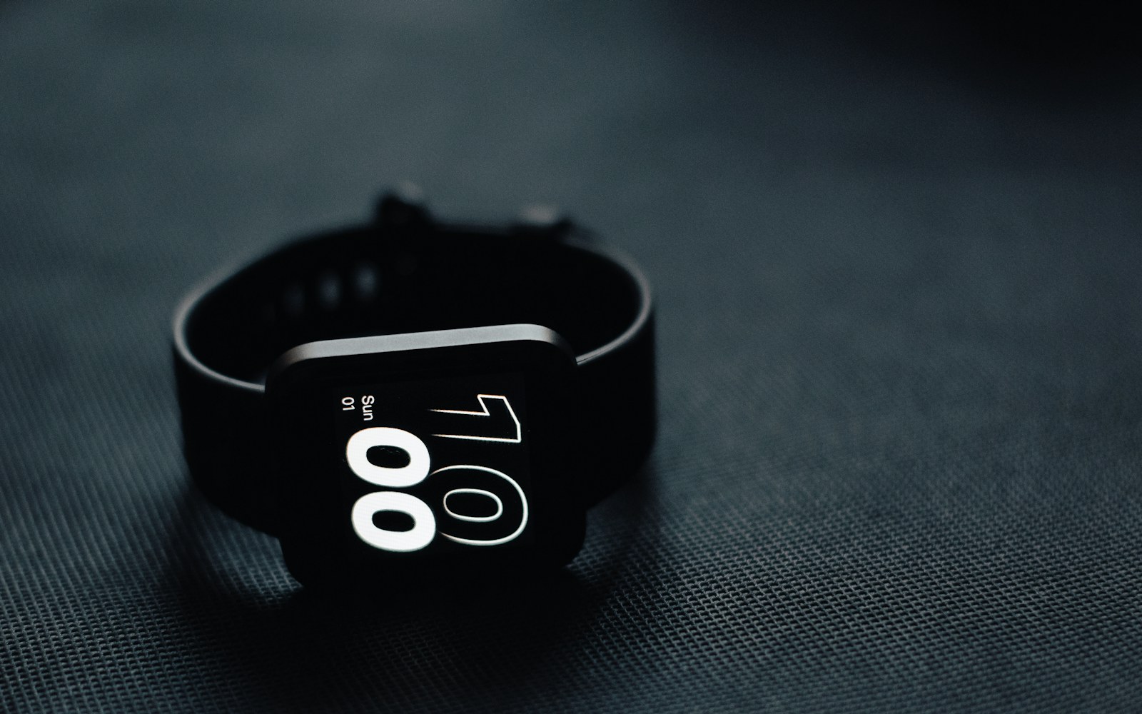 Fitness watch displaying the number 100 on a dark surface