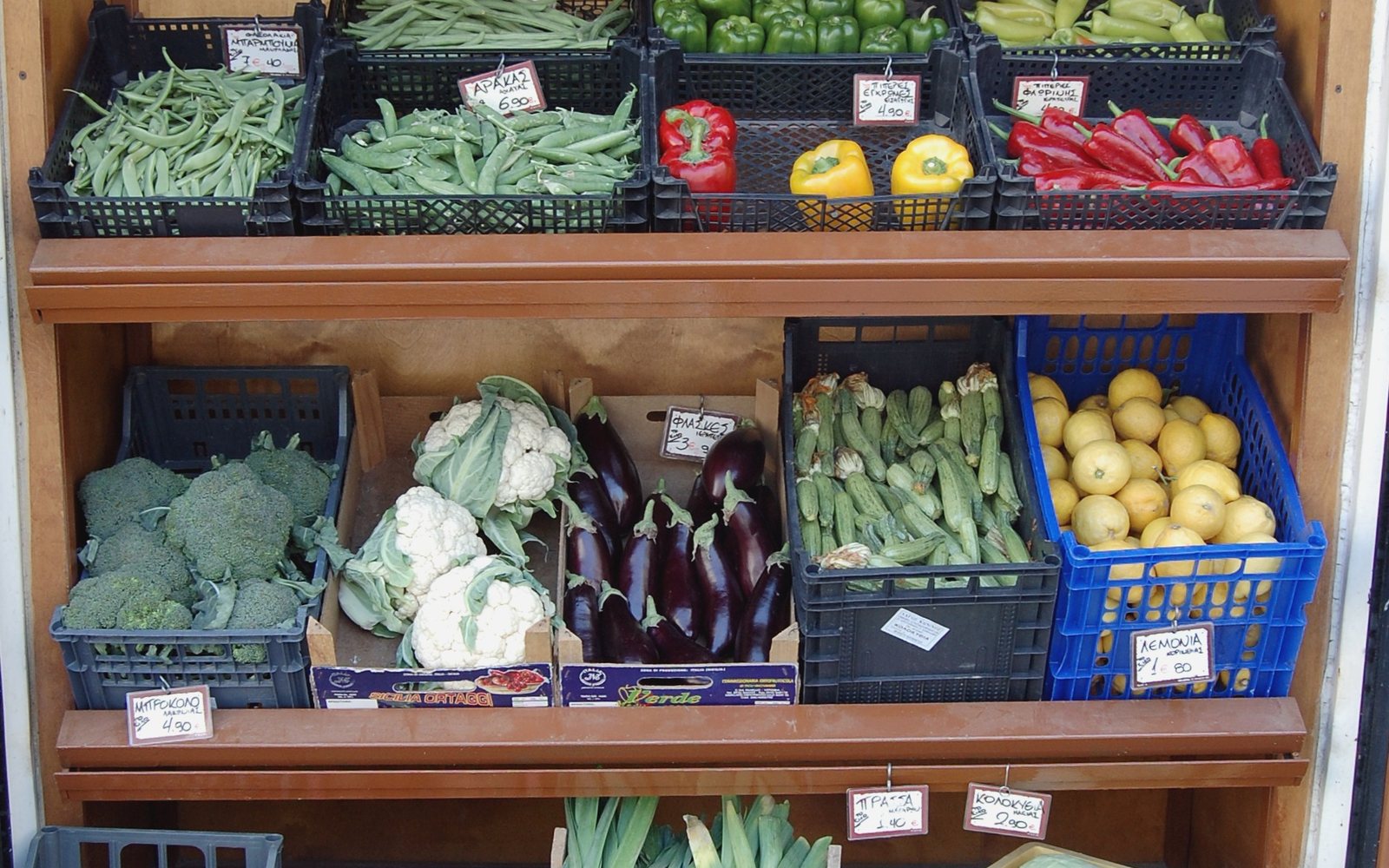 Crates of colorful vegetables arranged at a market stall.