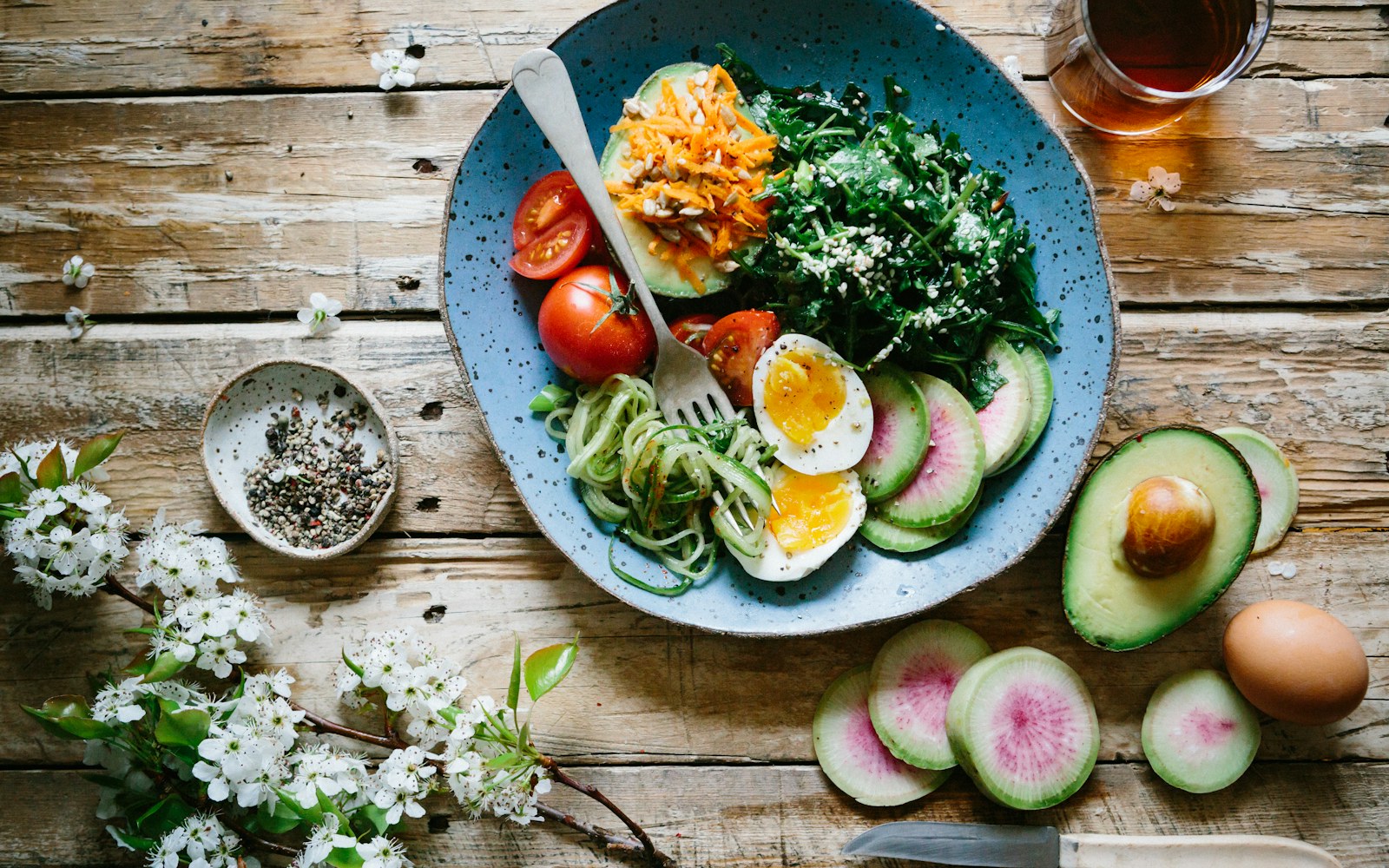 Plate with eggs, leafy greens, radishes, avocado, and seeds