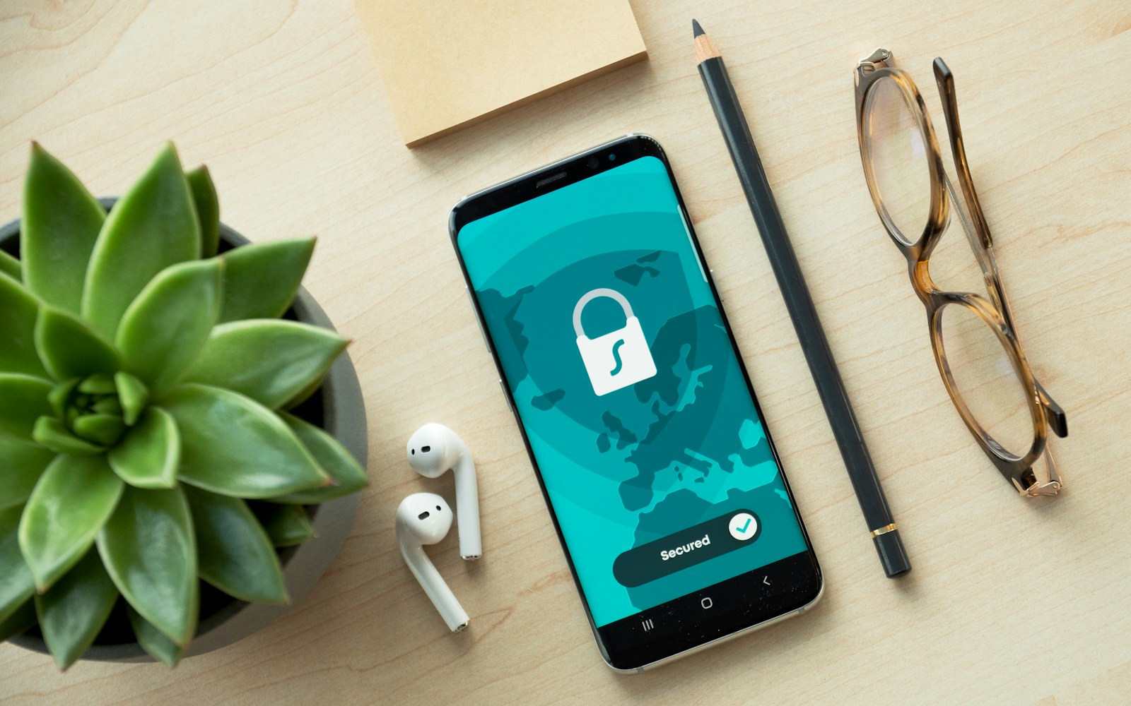 Smartphone displaying a digital lock beside glasses and earbuds