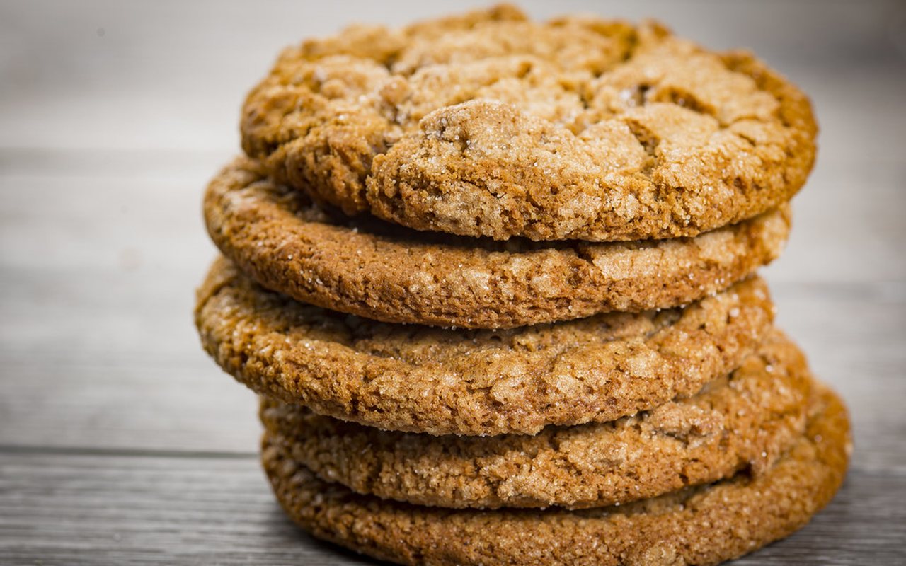 Brown ginger and cinnamon cutout cookies arranged on parchment paper