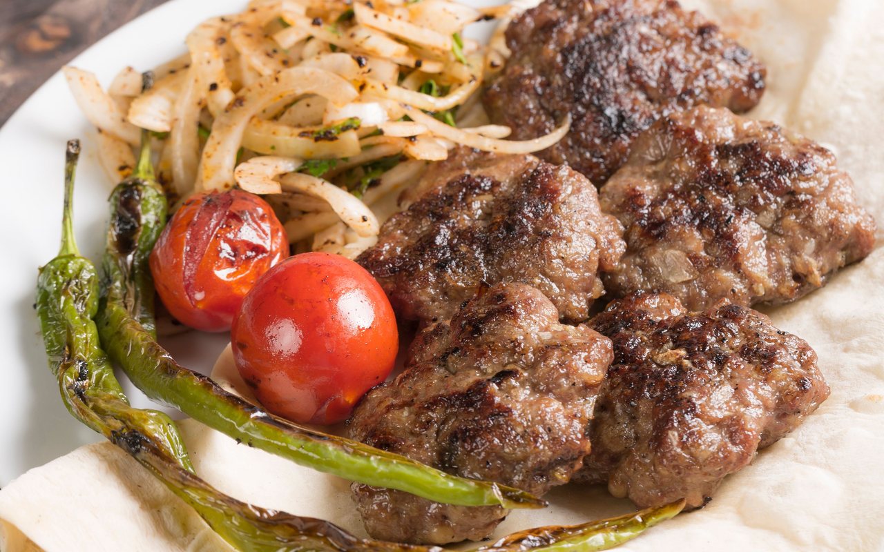 Grilled Turkish köfte patties on a serving plate