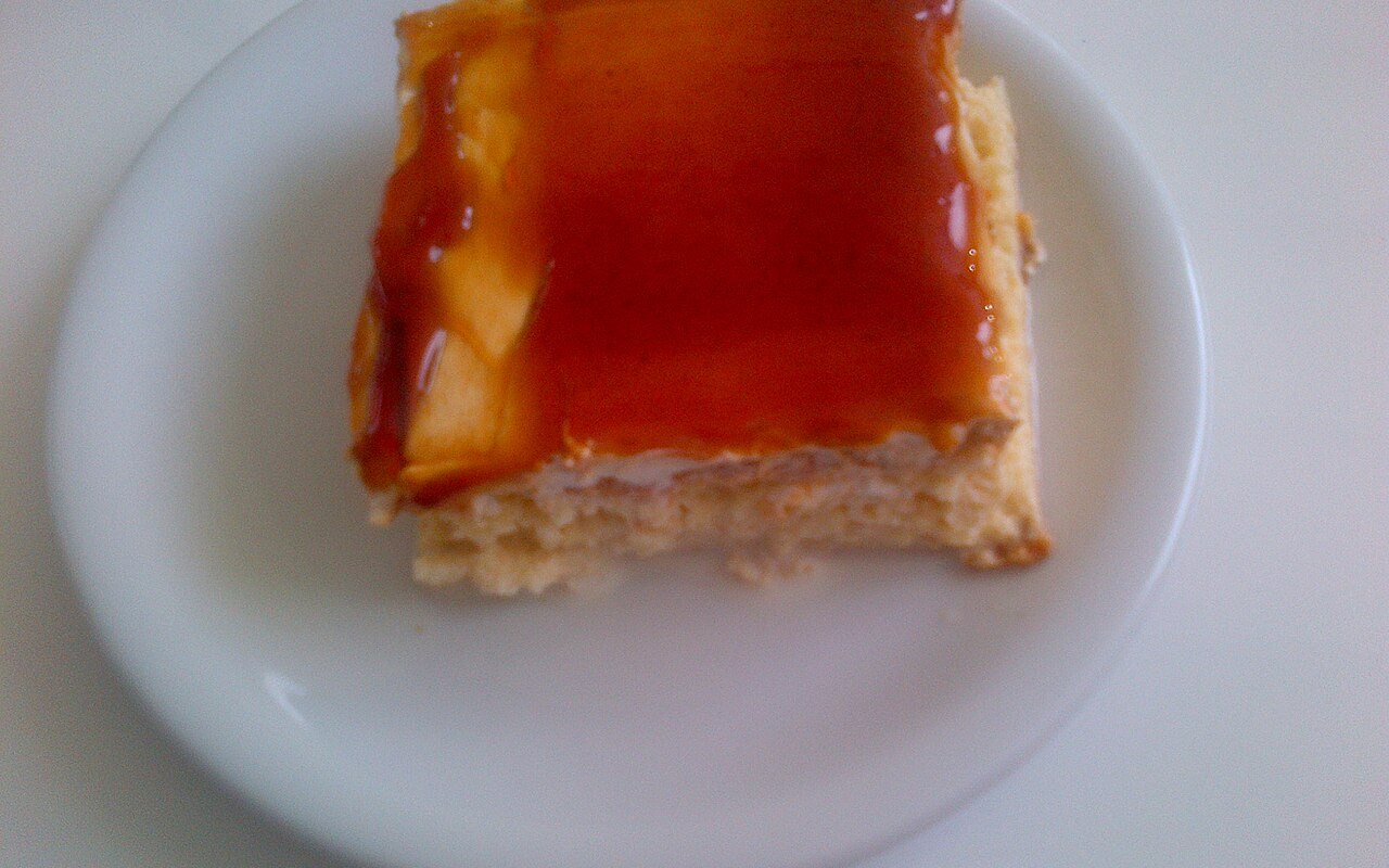 A slice of milk-soaked sponge cake topped with a smooth caramel layer