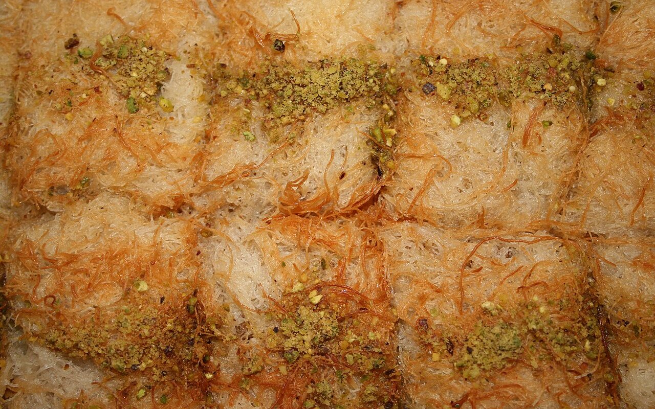 Golden squares of walnut kadayıf dessert topped with pistachio