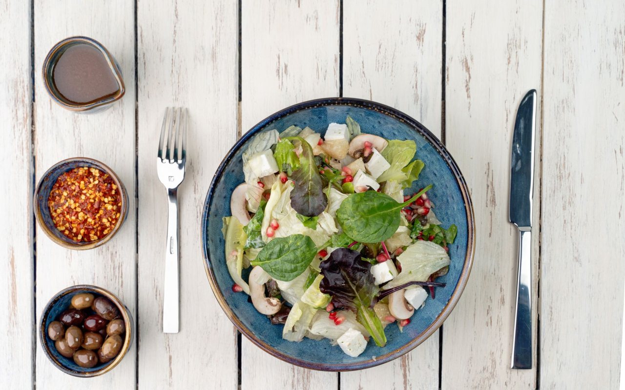 Arugula salad with white cheese, cherry tomatoes, and pomegranate arils